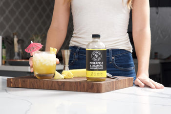 A tropical margarita garnished with an umbrella and made with Bravado Spice Co.’s Pineapple & Jalapeño Margarita Mix served over crushed ice.