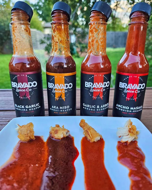 Close-up texture of Bravado Spice Company super-hot sauces with bits of chicken wings mixed in.