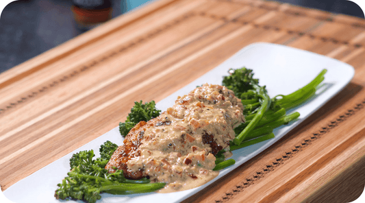 Blackened catfish with sauce over bed of vegetables