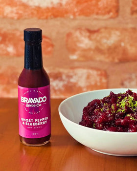 Bravado Ghost Pepper & Blueberry hot sauce beside a bowl of rich, zesty cranberry sauce.