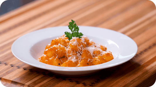 gnocchi in a white bowl with basil garnish